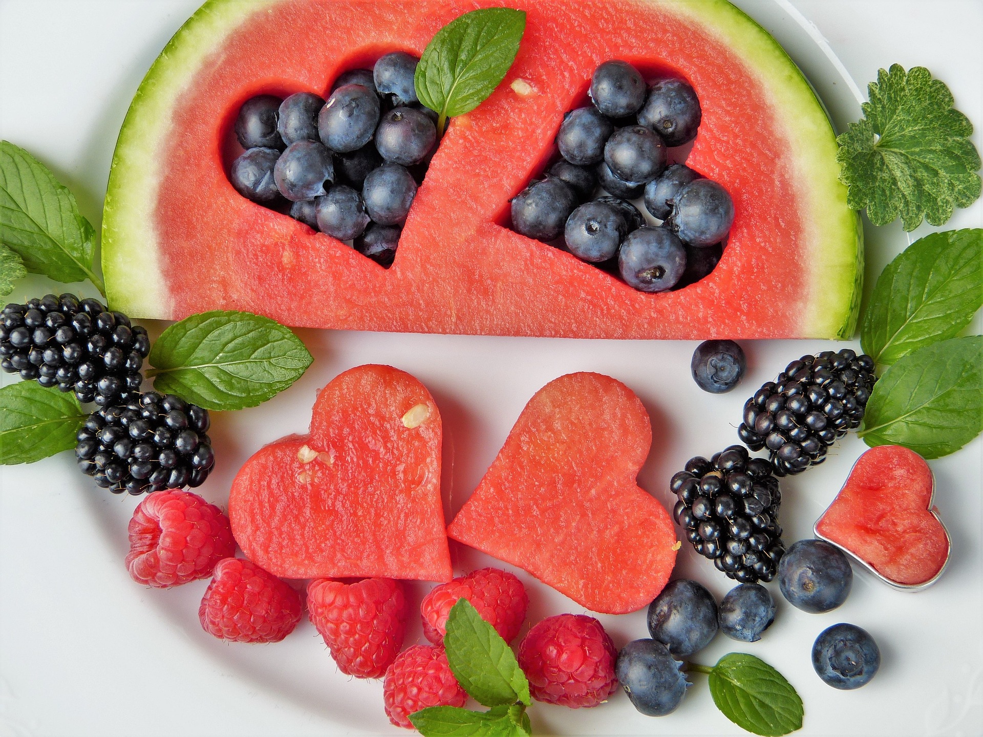 Blackberries, blueberries, and watermelon arranged in a heart pattern to represent their nourishing qualities to the gut-body-brian axis.